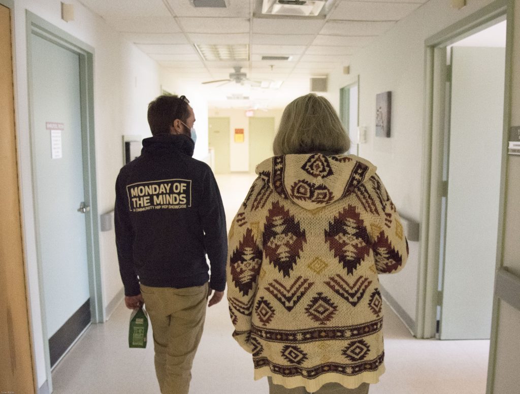 zach and his mother, terry walking in nursing home halls. Walls are white, no decorations.