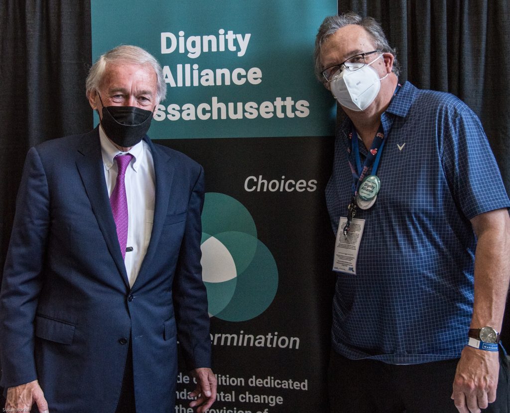 Senator Ed Markey with Paul Lanzikos in front of DignityMA banner.